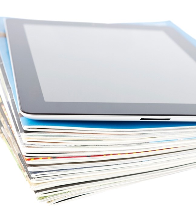 A tablet on a stack of magazines