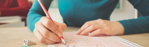 student taking a test with a pencil