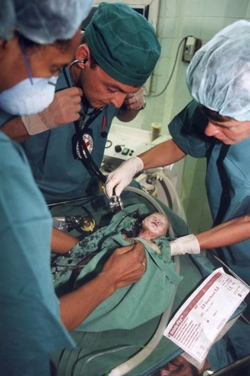 Doctors working on a very small baby.