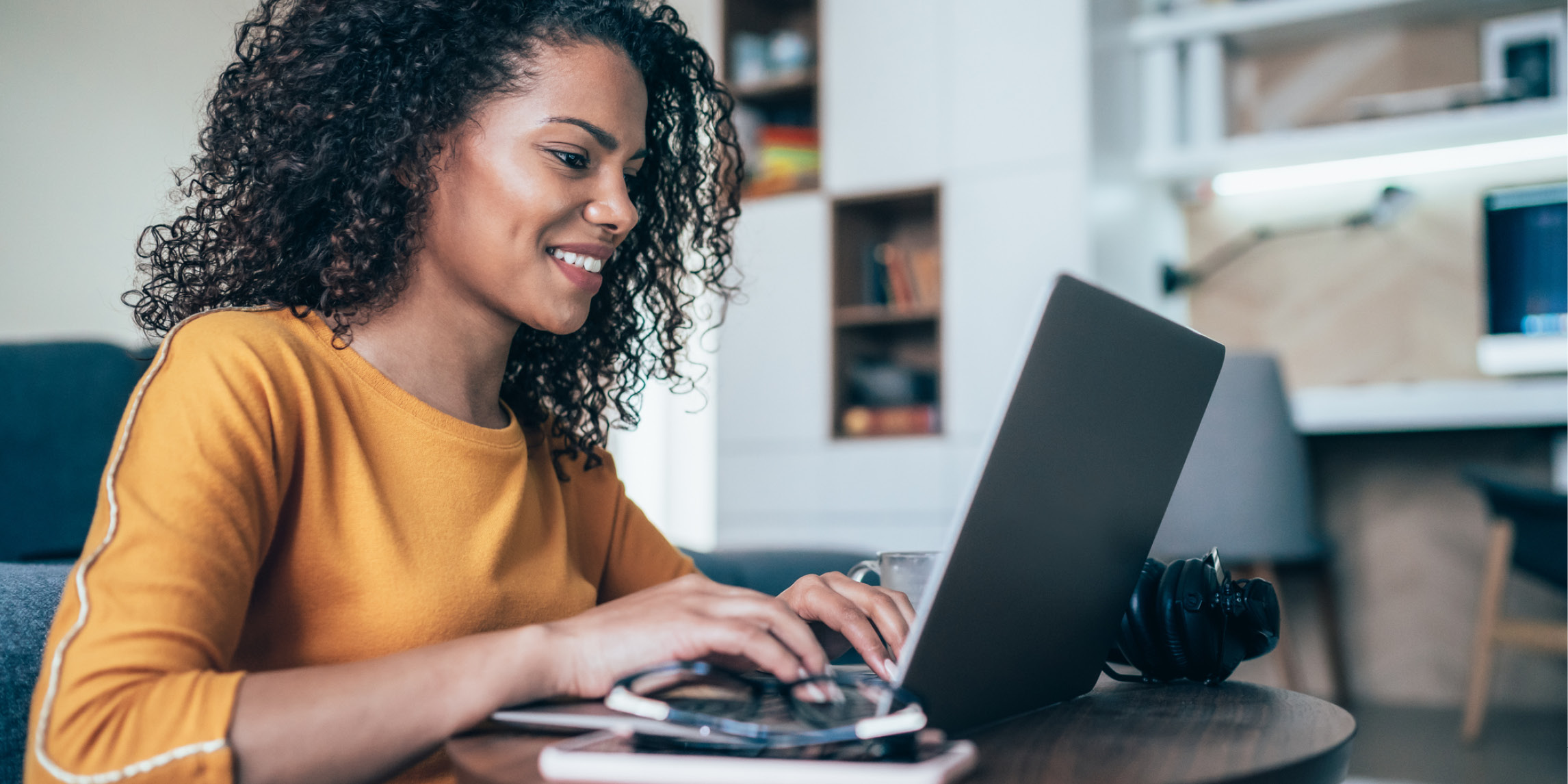 A woman smiling in front of a laptop