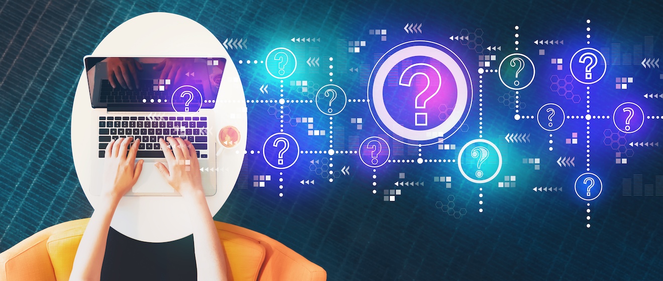 Hands typing on a laptop with digital question marks