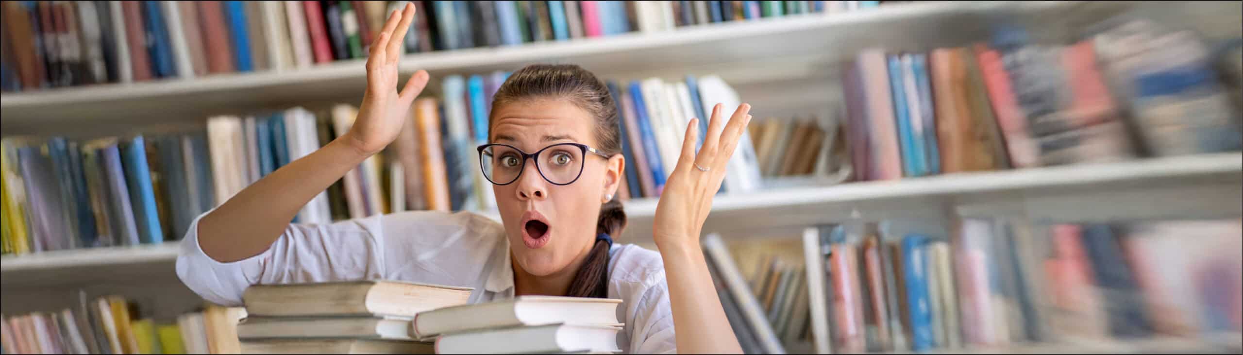 A person in a library with hands in the air