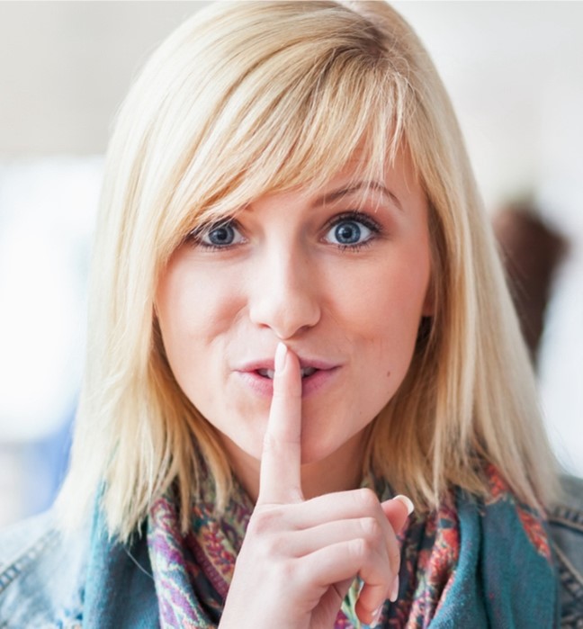 Person saying to be quiet with her finger over her mouth